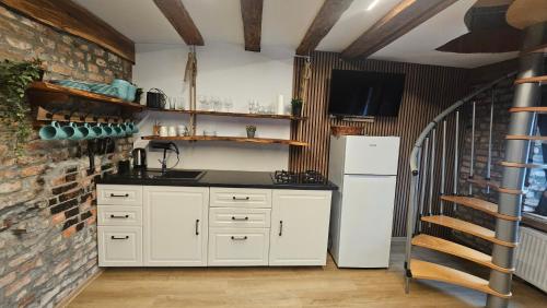 a kitchen with a white refrigerator and a brick wall at Hiša stare mame in Kamnik