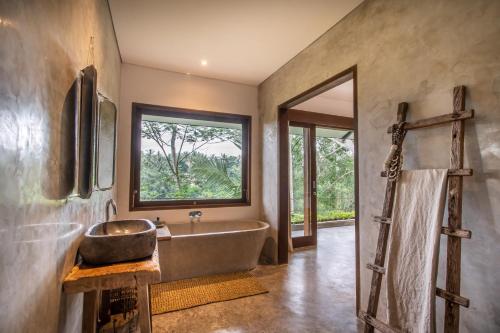 a bathroom with a large tub and a window at The Hidden Paradise Ubud - CHSE Certified in Ubud
