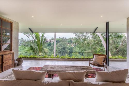 a living room with a couch and a large window at The Hidden Paradise Ubud - CHSE Certified in Ubud