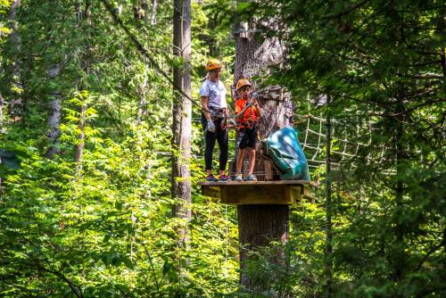 two people standing on a platform in the forest at Holiday Inn St-Jean-sur-Richelieu Congrès by IHG in Saint-Jean-sur-Richelieu