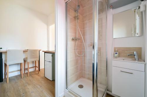une salle de bain avec douche et lavabo dans l'établissement Le petit havrais, au Havre