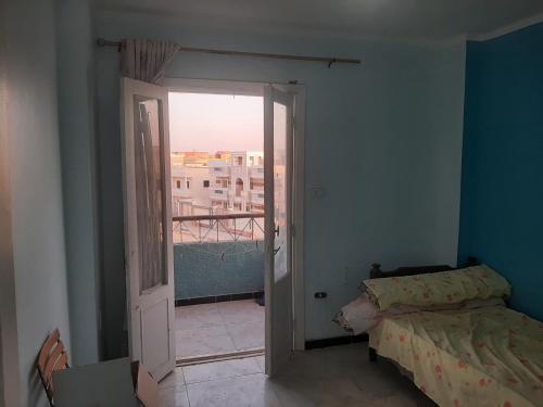 a bedroom with a door open to a balcony at Minya House in Sawādah