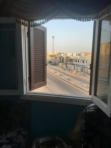an open window with a view of a city street at Minya House in Sawādah