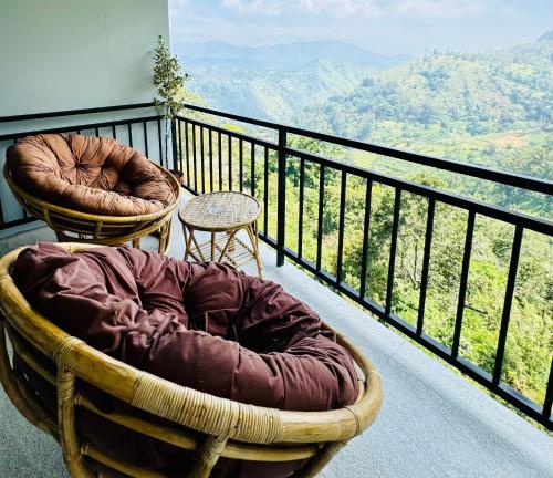a balcony with two chairs and a table on a balcony at Will Guest Homestay in Ella