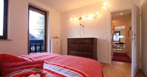 a bedroom with a bed and a dresser and a window at Enzian 14 - Schmuckstück von Bad Kleinkirchheim in Bad Kleinkirchheim