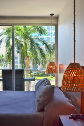 a bedroom with a bed and a large window at Estudio Marino in Nuevo Vallarta