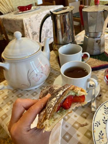 a person holding a piece of bread with a cup of coffee at B&B Casa Michele in Taormina