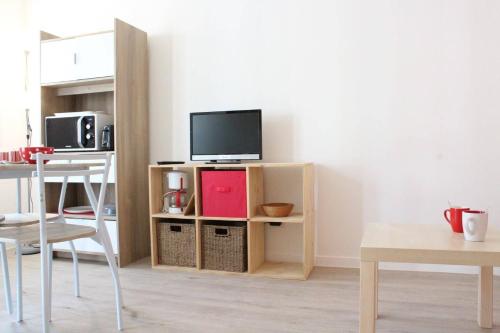 un salon avec une télévision sur un support en bois dans l'établissement Studio LA ROCHELLE - LR100-521, à La Rochelle