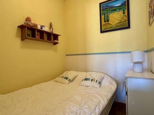 - une petite chambre avec un lit et une photo sur le mur dans l'établissement Studio cabine 4 couchages, terrasse et barbecue, proche plages et commerces - Argelès-sur-Mer - FR-1-225-114, à Argelès-sur-Mer