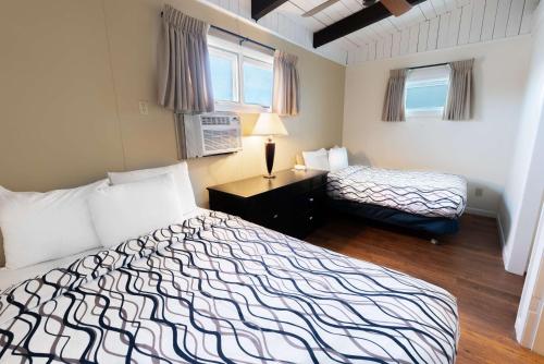 a hotel room with two beds and a desk and window at Ocean House Boutique Hotel & Motel in Old Orchard Beach
