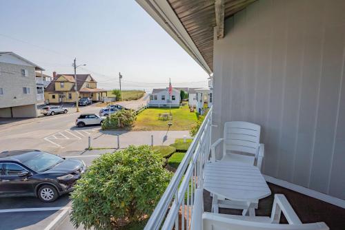 a balcony with two white chairs and a parking lot at The Gull Oceanside Inn & Motel in Old Orchard Beach