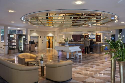 a lobby with a white piano in a building at Maritim Hotel Bad Wildungen in Bad Wildungen