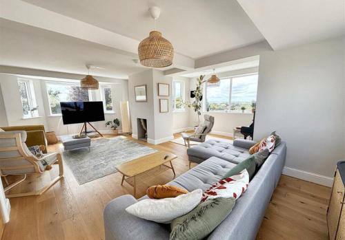 a living room with a couch and a tv at Stunning home with magnificent views in East Devon in Exeter