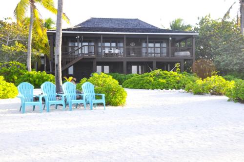 a table and chairs in front of a house at Featherstone Downstairs Apartment, Cayman Brac in Cayman Brac
