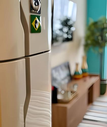 a refrigerator in a living room with a couch at Chic retrô no Flamengo in Rio de Janeiro