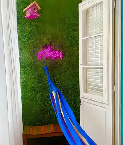 an open door with an umbrella next to a green wall at Chic retrô no Flamengo in Rio de Janeiro