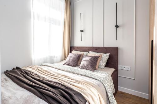 a bedroom with a bed with white walls and a window at SuperApart Mińska Apt 3 - Blisko Stadionu Narodowego in Warsaw