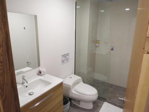 a bathroom with a toilet and a sink and a shower at HOTEL A & A SANTA ALEJANDRIA in Medellín