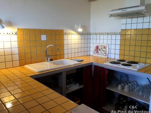 a kitchen with a sink and a stove at AU PIED DU VENTOUX in Flassan