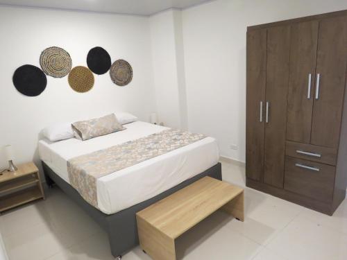 a bedroom with a bed and a wooden cabinet at HOTEL A & A SANTA ALEJANDRIA in Medellín