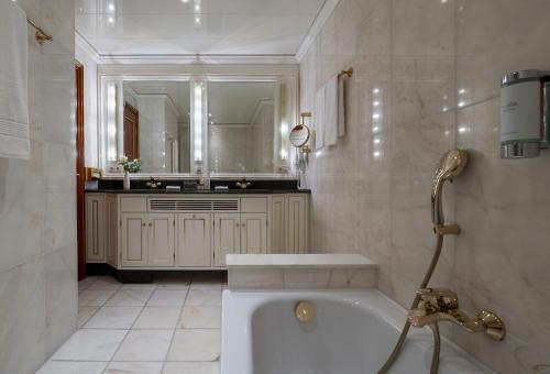 a white bathroom with a tub and a sink at Maritim Hotel Bad Wildungen in Bad Wildungen