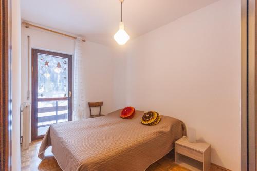 a bedroom with a bed with two pillows on it at Condominio Val Biois in Falcade