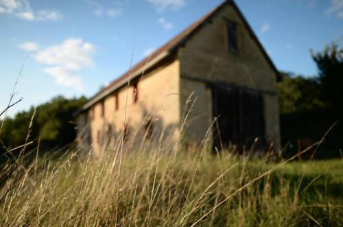 une ancienne grange dans un champ d'herbe haute dans l'établissement Les Bories - Loft in nature, à Urval