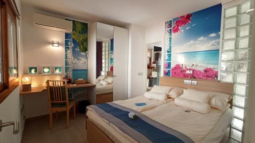 a bedroom with a bed with a large painting on the wall at Parrot Cage - the Gay Villa in Playa del Ingles