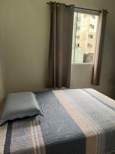 ein Bett mit einem Kissen in einem Schlafzimmer mit einem Fenster in der Unterkunft Apartamento em Belém- cop30 in Ananindeua