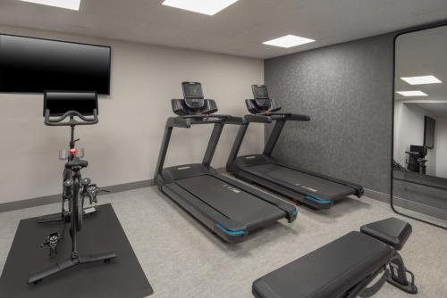 a gym with two treadmills and a flat screen tv at Holiday Inn Express South Burlington - Downtown by IHG in Burlington