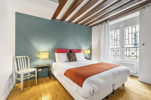 une chambre avec un grand lit et une chaise dans l'établissement Bahia, à Paris