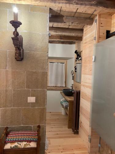 a hallway of a kitchen with a refrigerator and a sink at La Cà di Tonia e Abigaille in Songavazzo