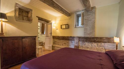 a bedroom with a bed and a brick wall at Da Bacchetta in Assisi
