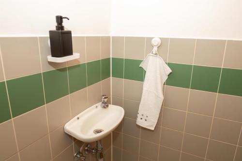 a bathroom with a sink and a soap dispenser at BergZeit Apartments in Spital am Semmering