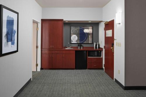 a kitchen with red cabinets and a sink in a room at Courtyard Charlottesville - University Medical Center in Charlottesville