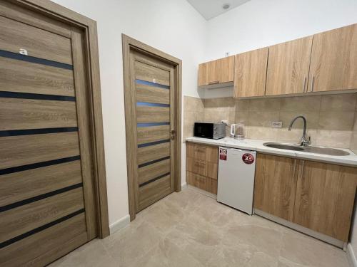 a small kitchen with a sink and a refrigerator at Апарт-готель Олімпік in Lviv