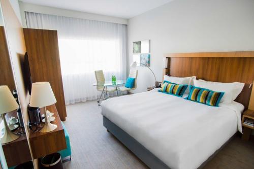 a bedroom with a large bed in a hotel room at Courtyard by Marriott Gdynia Waterfront in Gdynia