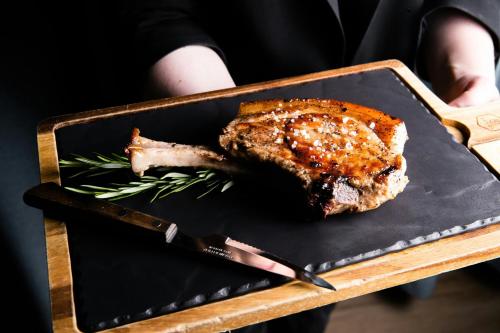 a piece of meat on a plate with a knife at Courtyard by Marriott Gdynia Waterfront in Gdynia