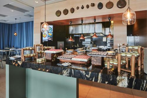 a restaurant with a counter with food on it at Courtyard by Marriott Gdynia Waterfront in Gdynia