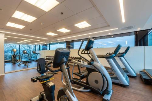 a gym with several treadmills and elliptical machines at Courtyard by Marriott Gdynia Waterfront in Gdynia