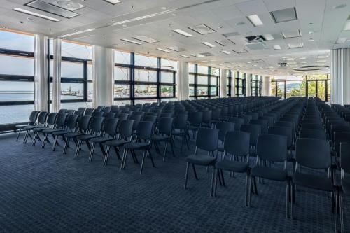 an empty room with chairs in a building with windows at Courtyard by Marriott Gdynia Waterfront in Gdynia