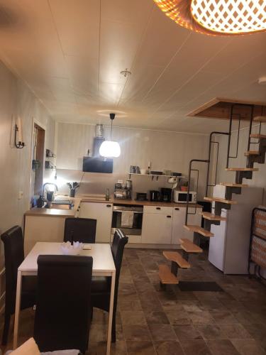 a kitchen and dining room with a table and chairs at A cosy little house in Solsidan