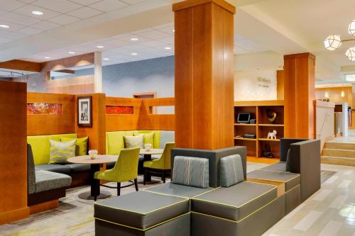 a waiting room with a table and chairs at Courtyard by Marriott Boston Logan Airport in Boston