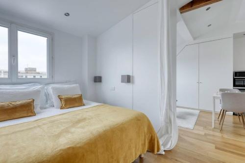 une chambre blanche avec un grand lit et une table dans l'établissement Classy, New & Large Designed Studio - Paris 16, à Paris