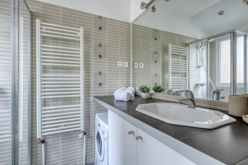une salle de bain avec un lavabo et une machine à laver dans l'établissement Classy, New & Large Designed Studio - Paris 16, à Paris