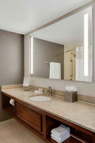 a bathroom with a sink and a large mirror at Courtyard by Marriott Boston Logan Airport in Boston
