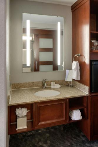 a bathroom with a sink and a large mirror at Courtyard by Marriott Boston Logan Airport in Boston