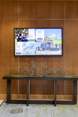 a table in a room with a tv on a wall at Courtyard by Marriott Boston Logan Airport in Boston