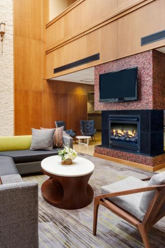 a living room with a couch and a fireplace at Courtyard by Marriott Boston Logan Airport in Boston