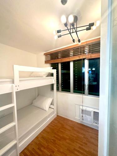 a bedroom with bunk beds and a window at EDSA Cozy 3BR near MRT w Netflix and Karaoke Fun in Manila